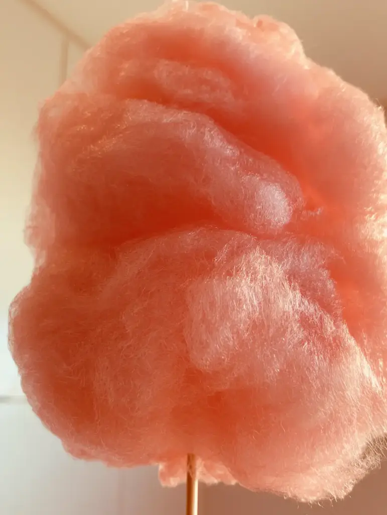 Capas aireadas y wispy de algodón de azúcar rosa en una cocina moderna con luz natural.