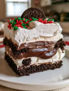 Primer plano de las capas de una lasaña de oreo mostrando la base oscura, el queso crema y el pudín de chocolate. (lasaña de oreo)